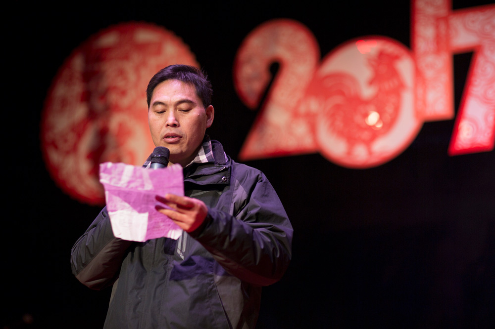 Chen Nianxi reads a poem at a Spring Festival gala organized for migrant workers in Pi Village, Beijing, January 2017. Yang Jia/IC