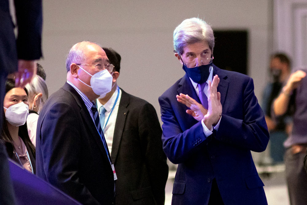 Xie Zhenhua (left), China’s Special Envoy for Climate Change, talks to U.S. envoy John Kerry prior to a COP26 plenary session in Glasgow, Scotland, Nov. 13, 2021. Robert Perry/EPA via IC