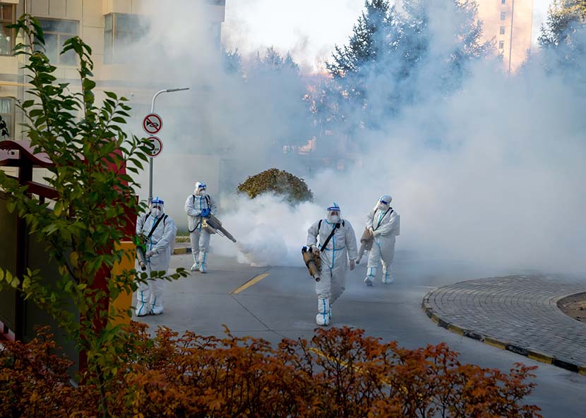Coronavirus control workers sterilize a residential area in Zhangye, Gansu province, Oct. 30, 2021. IC