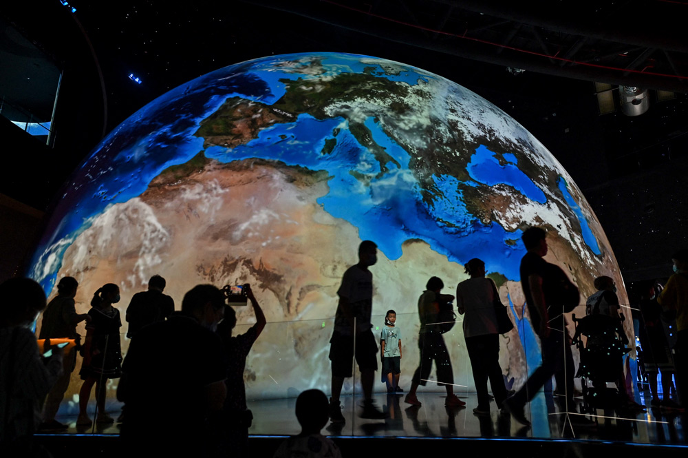 A display shows a mockup of the Earth at the Shanghai Planetarium, July 30, 2021. Hector Retamal/AFP