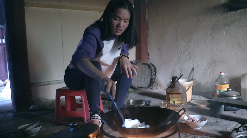 Li Leyou cooks at home in Zongla Village, Yunnan province, 2021. Zhao Zhiyuan/The Paper