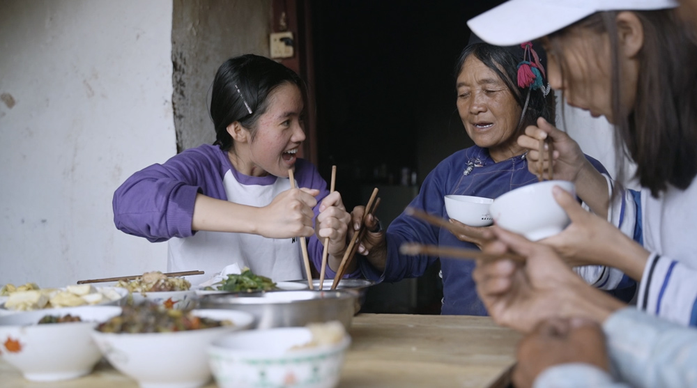 Li Leyou shares a meal with her aunt and grandmother in Zongla Village, Yunnan province, 2021. Zhao Zhiyuan/The Paper