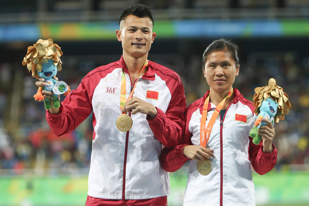 Gold medalist Liu Cuiqing (right) and her guide Xu Donglin pose on the podium at the medal ceremony for the Women’s 400m (T11) during the Rio 2016 Paralympic Games in Brazil, Sept. 16, 2016. Lucas Uebel via People Visual