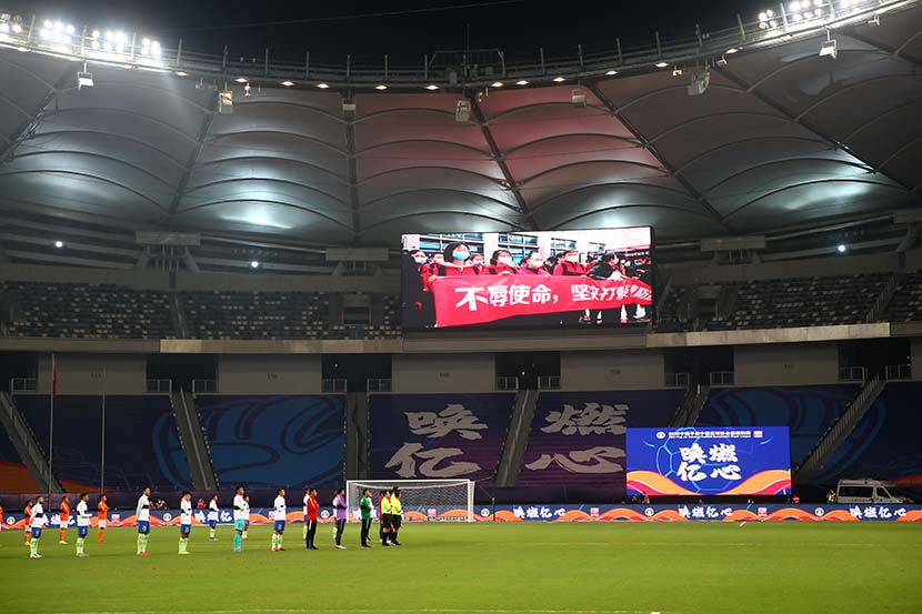 Players stand for a moment of silence in memory of the people who have died during the COVID-19 pandemic before a 2020 Chinese Super League match, in Suzhou, Jiangsu province, July 25, 2020. CNS/People Visual
