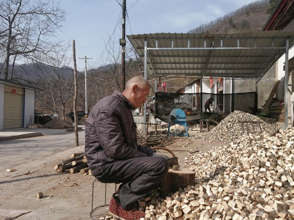 Zhang Guoqing chops wood in Yinhe Village, Shaanxi province, Feb. 7, 2021. Courtesy of Chen Nianxi