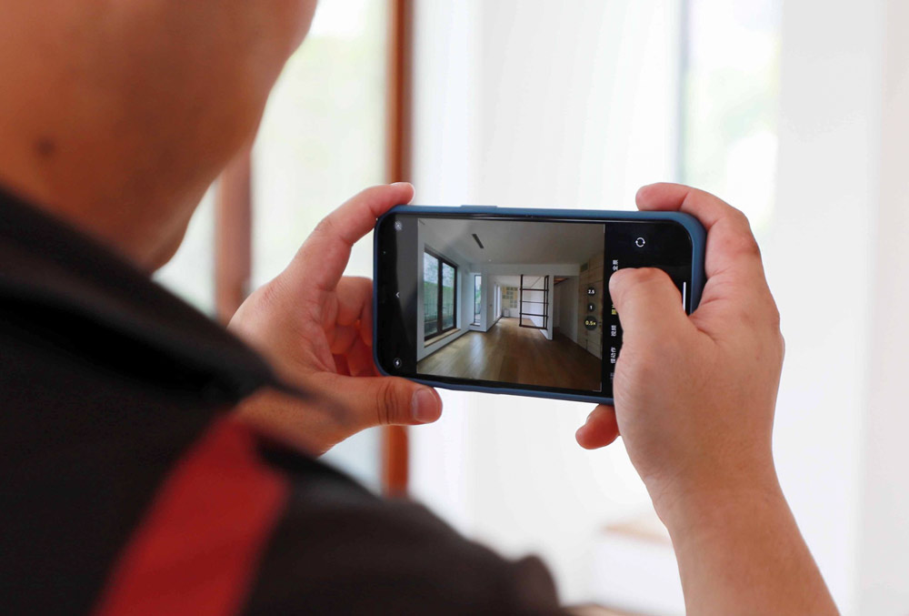 A real agent takes a photo of a house for sale for his clients, in Shanghai, Sept. 7, 2021. IC