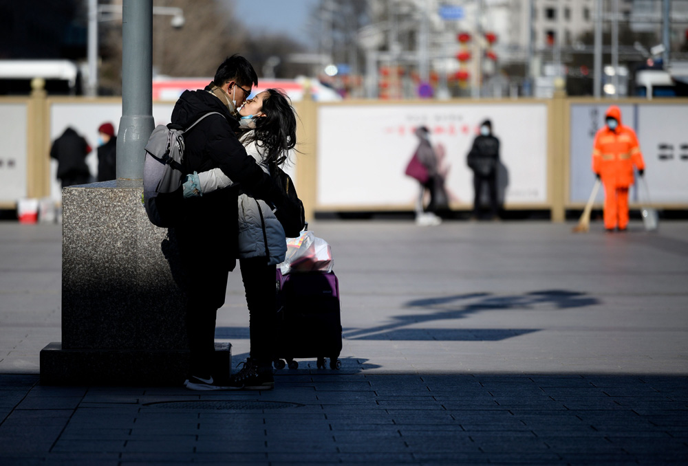 A couple embrace outside a Beijing railway station, Jan. 28, 2021. People Visual.