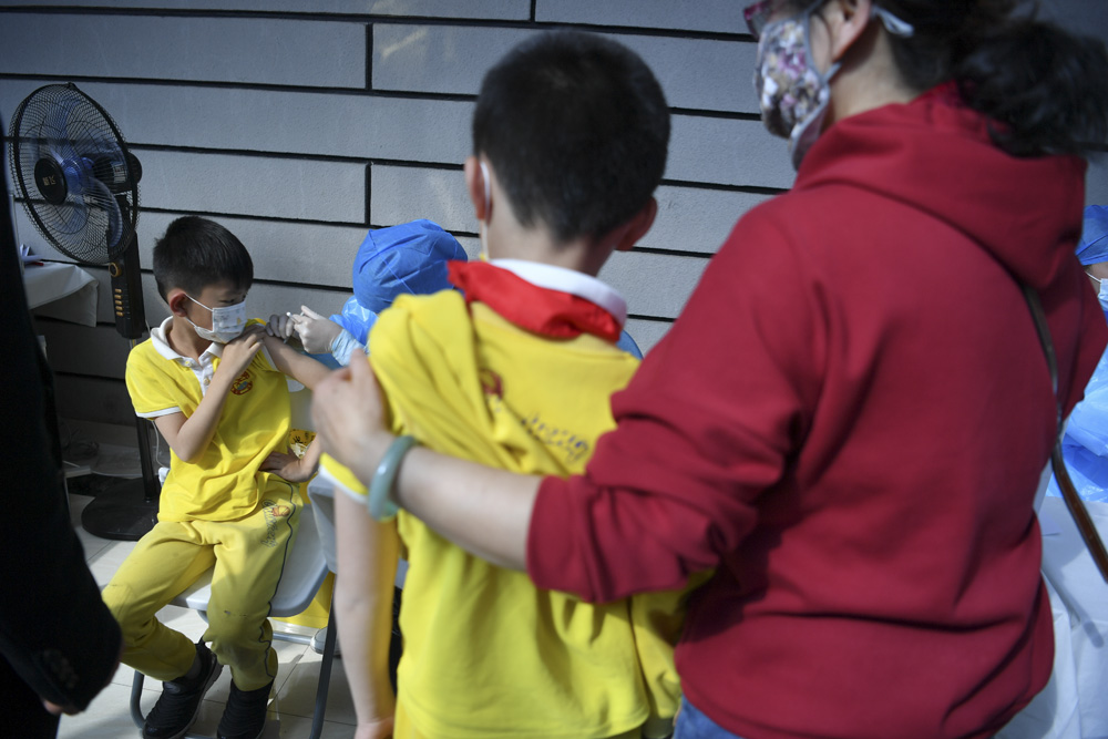 Primary school students get vaccinated with their parents in Kunming, Yunnan Province, Nov. 6, 2021. Liu Ranyang/ IC
