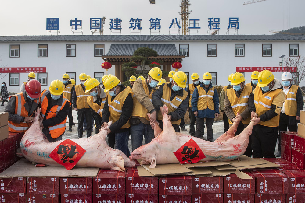 Construction workers distribute goods for the Lunar New Year at a construction site in Ningbo, Zhejiang province, Feb. 4, 2021. Hu Xuejun/VCG