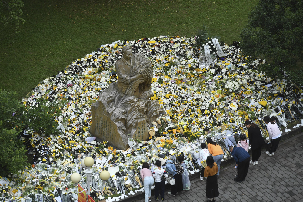 People leave flowers and other mementos at the statue of Yuan Longping on the campus of his alma mater, Southwest University in Chongqing, May 23, 2021. People Visual