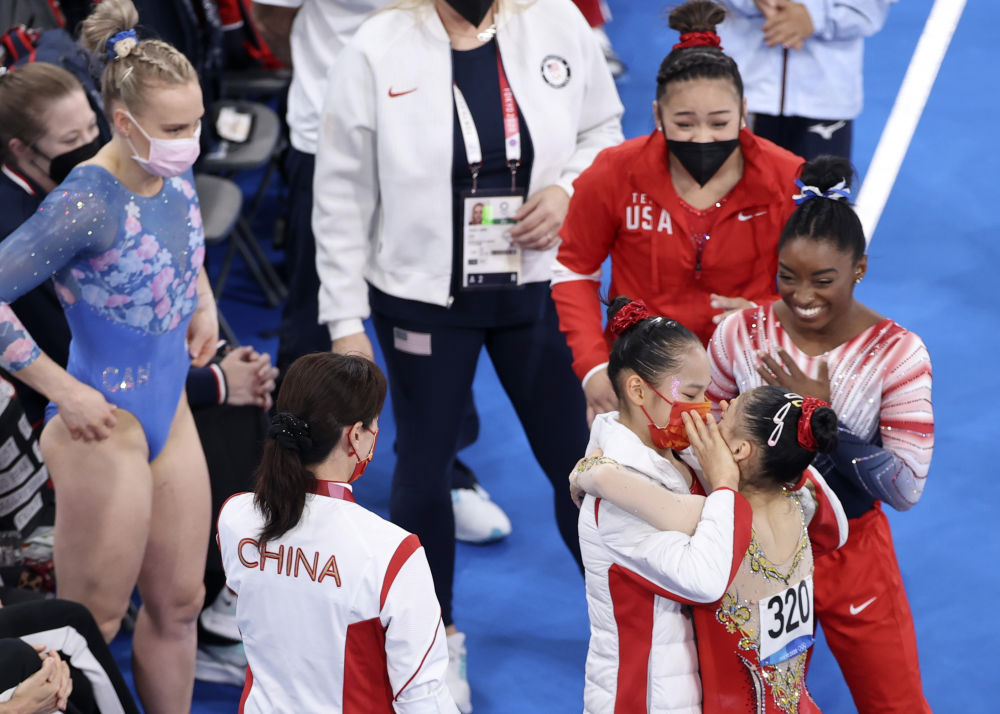 Tang Xijing and Guan Chenchen (No. 320) celebrate after the women’s balance beam final as the United States’ Simone Biles and Sunisa Lee look on, Aug. 3, 2021. Zheng Huansong/Xinhua