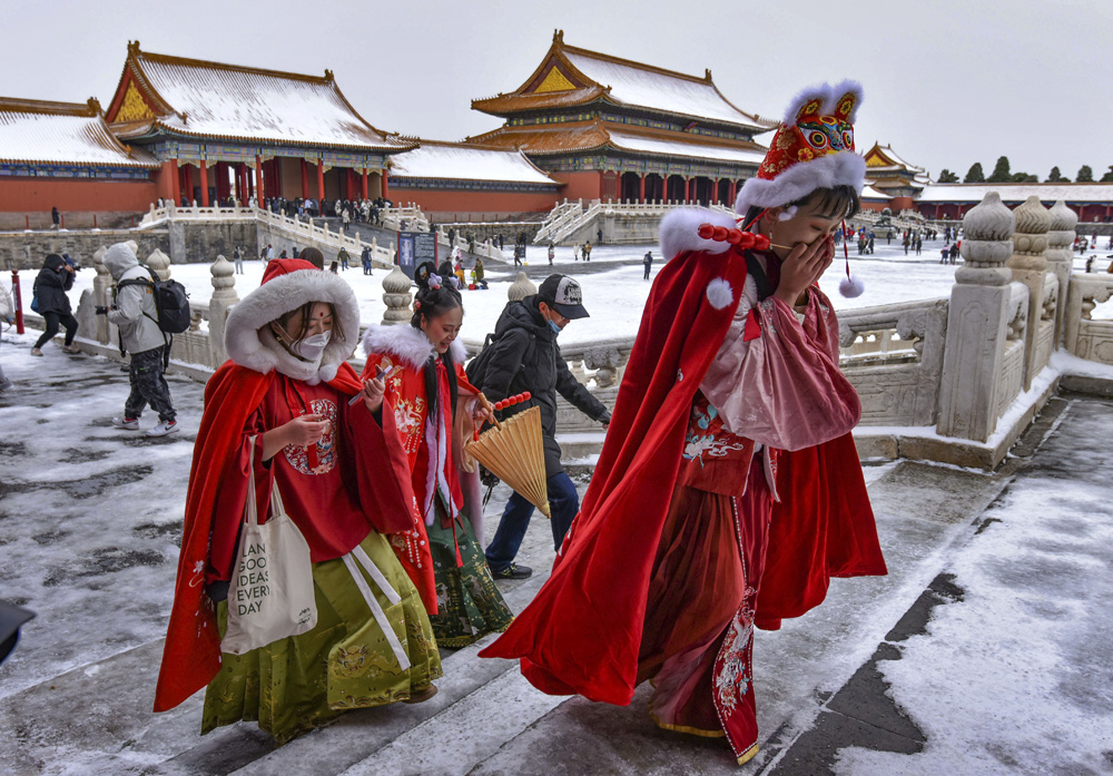 Tourists wearing colorful outfits visit the Palace Museum in Beijing after a snowfall, Nov. 6, 2021. Sheldon Cooper/Sipa USA via People Visual