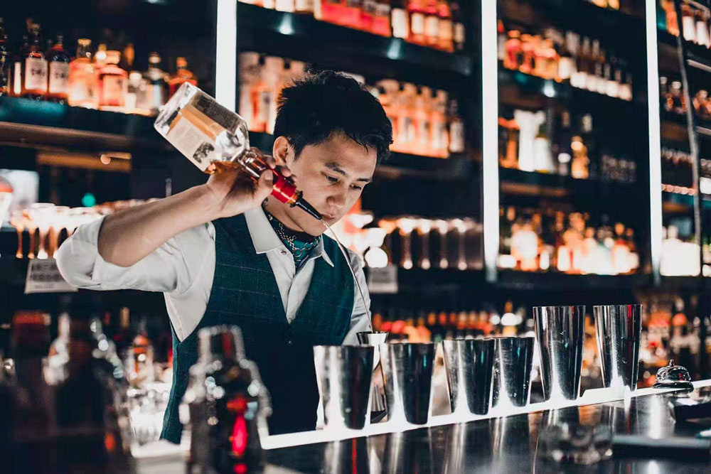 A bartender at Yao Xin’s whiskey bar, High Bridge, makes drinks with whiskey. Courtesy of Yao Xin