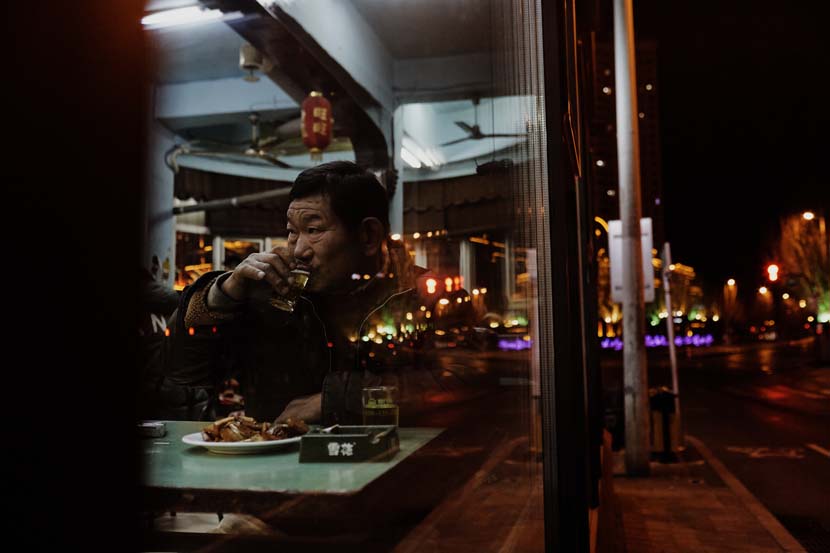 The rag collector drinks at the bar almost every day, in Shenyang, Liaoning province, Dec. 20, 2020. Wu Huiyuan/Sixth Tone