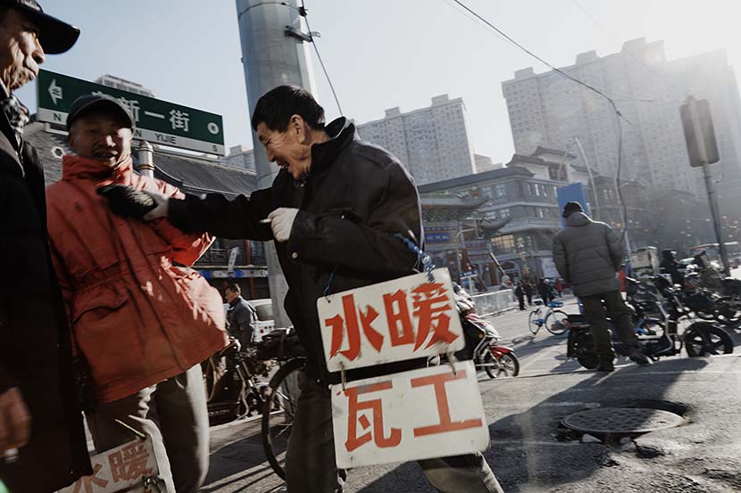 Men chat outside Wanshun Beerhouse, in Shenyang, Liaoning province, Dec. 21, 2020. Wu Huiyuan/Sixth Tone