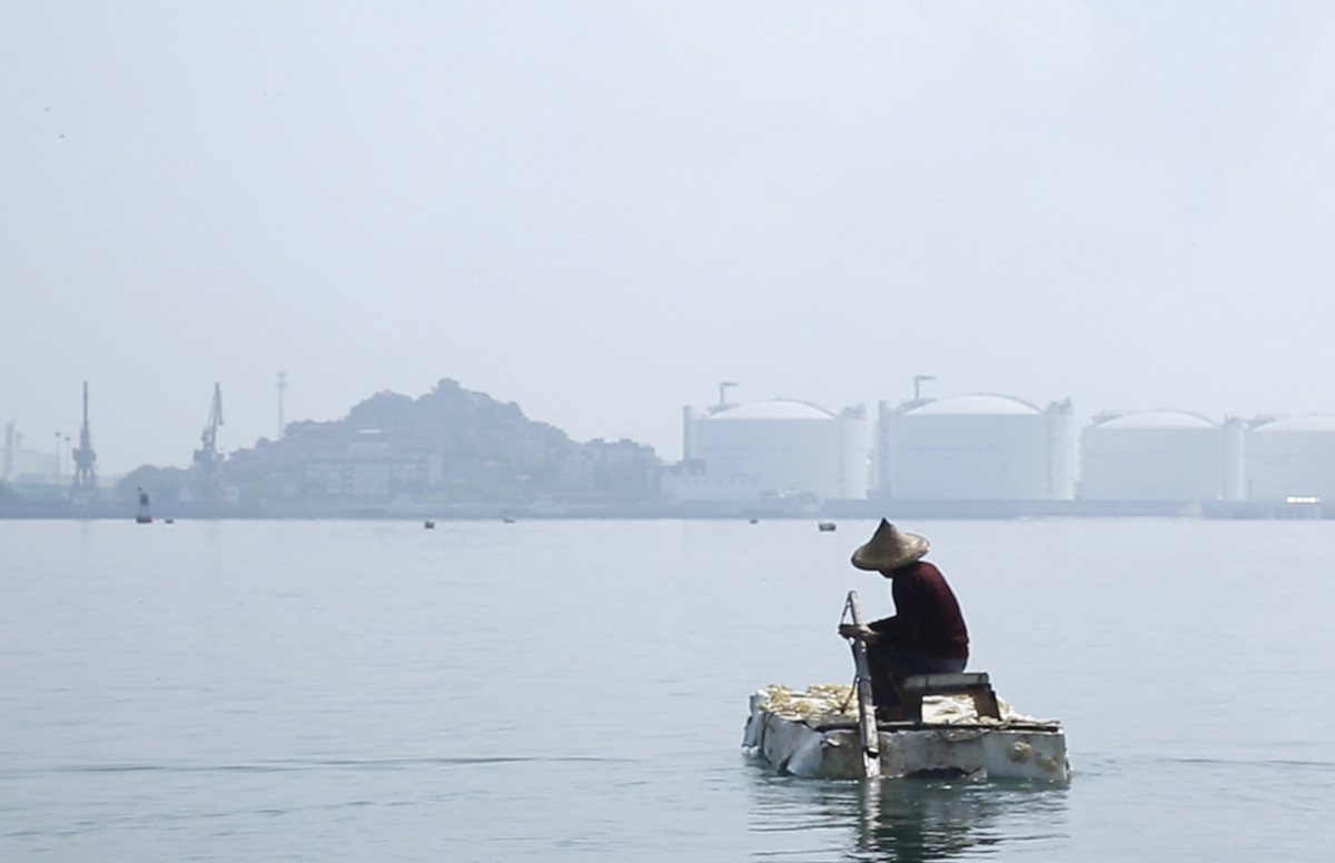 A screenshot shows a fisherman rowing a boat covered in mushrooms into waters affected by a petrochemical spill, from the project “Wonderland Intersection,” 2019. Courtesy of Long Pan