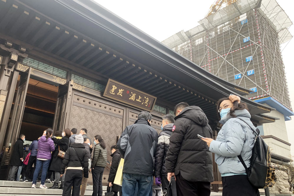 People line up to enter the sales center of a new development in Shanghai, Feb. 6, 2021. IC