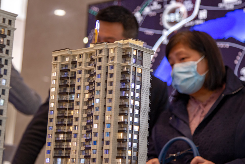Home buyers view a sand table model at a sales center in Shanghai, April 2020. People Visual