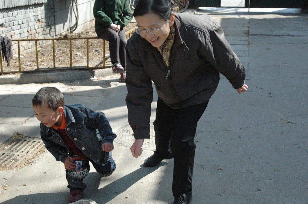 Zhang Yan plays games with a boy in Beijing, 2008. Courtesy of the interviewees
