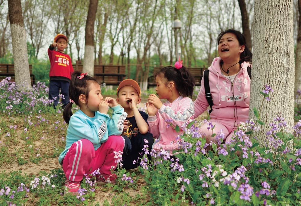 Ding Fengyun plays with children during a spring outing in Beijing, 2017. Courtesy of the interviewees