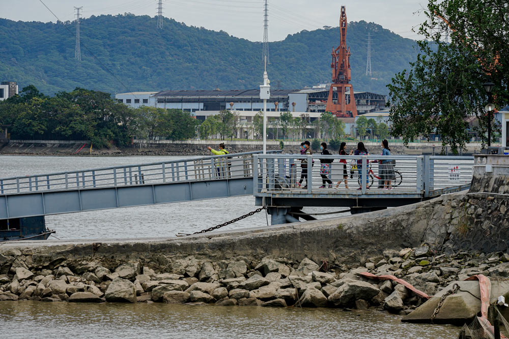 People stand by the bank of the Pearl River in Guangzhou, Guangdong province, Nov. 12, 2021. Wang Junxiang/People Visual