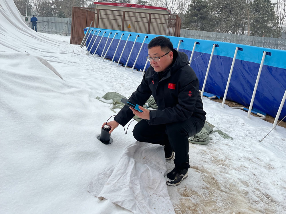 Wang Feiteng checks the grain size of stored artificial snow near Big Air Shougang stadium, Beijing, January 2022. Courtesy of Wang Feiteng