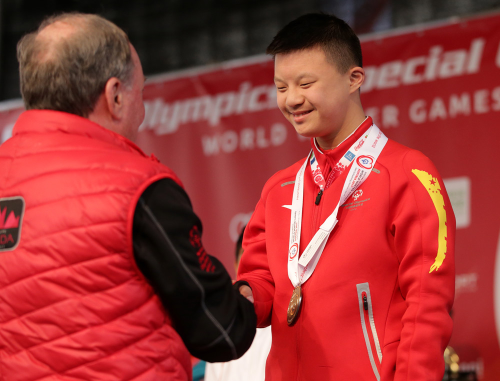 Li Xiang accepts a bronze medal at the 2017 Special Olympics World Winter Games in Austria, March 23, 2017. Courtesy of Yang Jianying