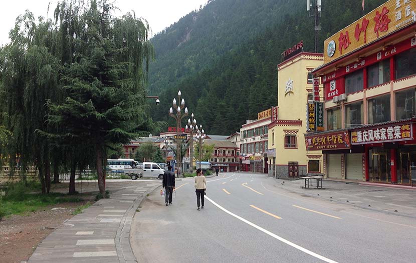 Residents walk by closed businesses outside Jiuzhaigou National Park in Sichuan province, Oct. 2, 2017. Wang Xin for Sixth Tone