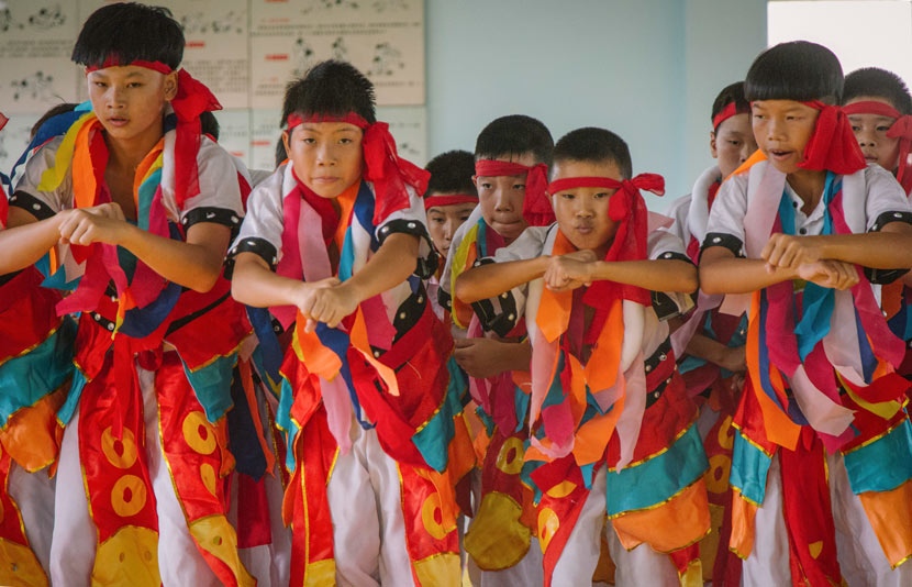 Young wrestlers in traditional ethnic Mongolian costumes perform a mix of wrestling moves and Mongolian dance at Matian Central Primary School in Luxi County, Jiangxi province, Sept. 5, 2017. Wu Huiyuan/Sixth Tone