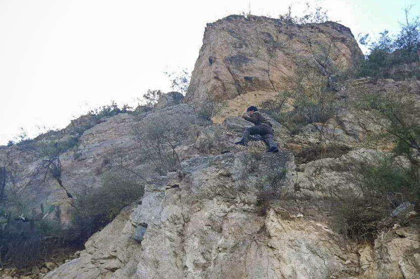 A member of Liu Jiewen’s meteorite-hunting group scales a cliff in Deqen County, Yunnan province, October 2017. Courtesy of Liu Jiewen