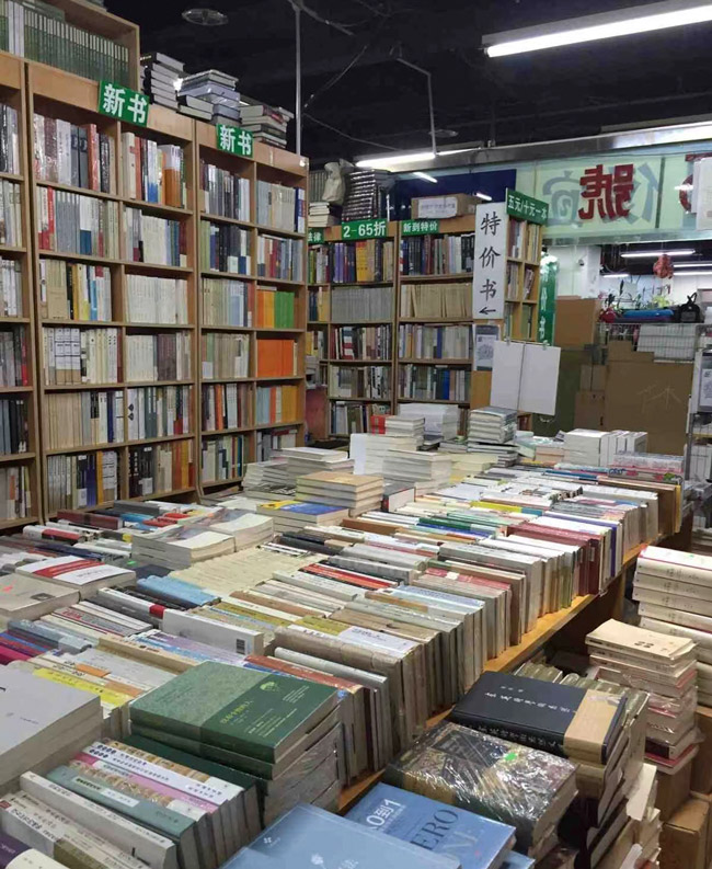 Books on display at the now closed Peking University campus location of Wild Grass Bookstore in Beijing, 2015. From @芳美明子 on Weibo