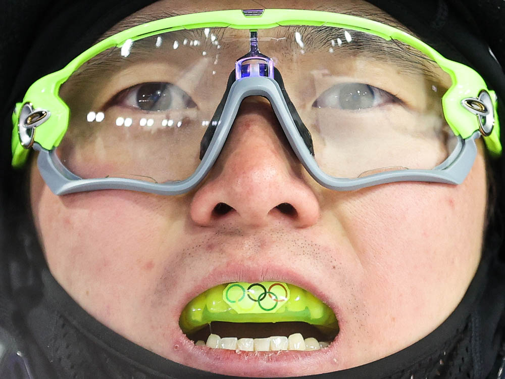 China’s Qi Guangpu of Team China shows his tooth protector after winning gold in men’s freestyle skiing aerials, Zhangjiakou, Feb. 16, 2022. Sergei Bobylev/TASS via VCG