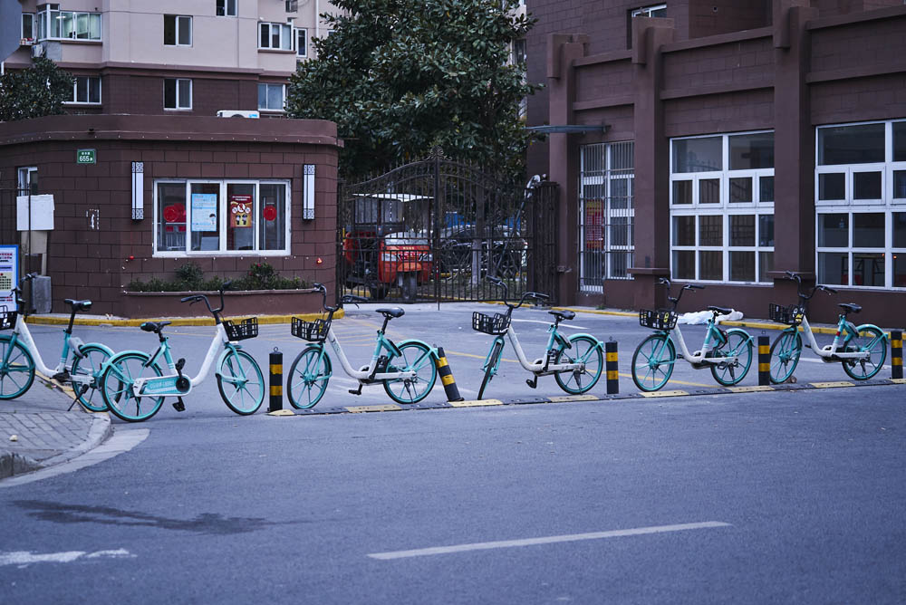 Shared bikes used as barriers at the entrance of a residential community in Baoshan District, Shanghai, March 16, 2022. Wu Huiyuan/Sixth Tone