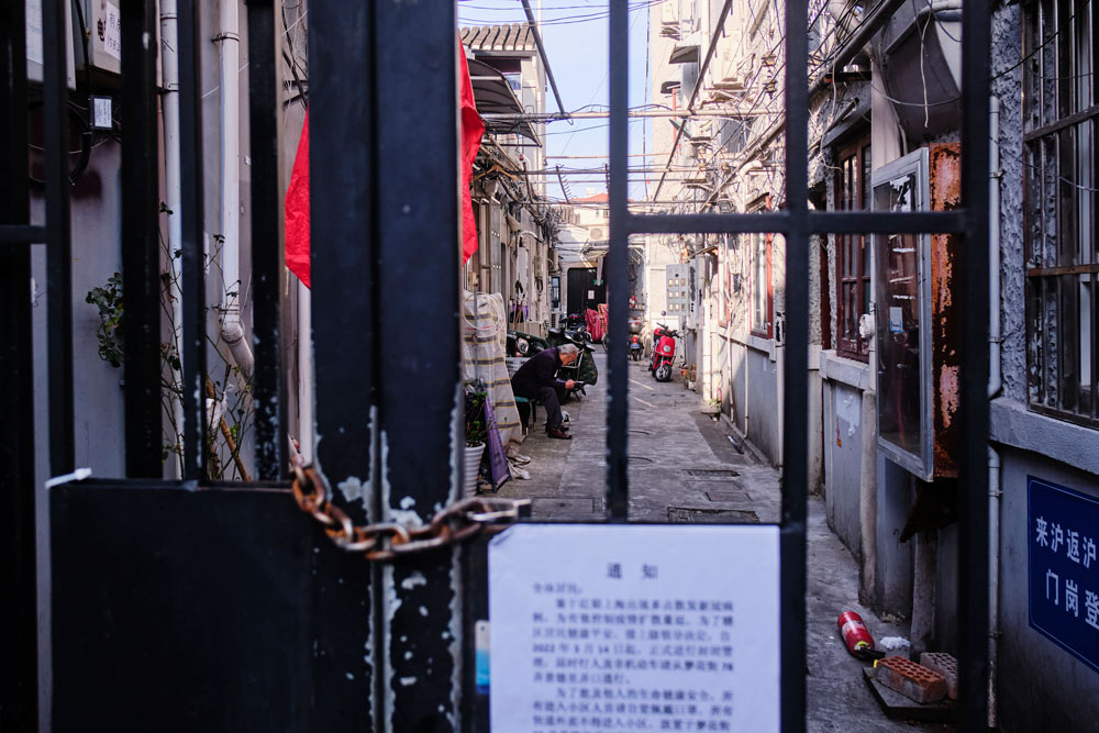 A man sits reading inside a locked down residential area in Shanghai, March 15, 2022. Wu Huiyuan/Sixth Tone