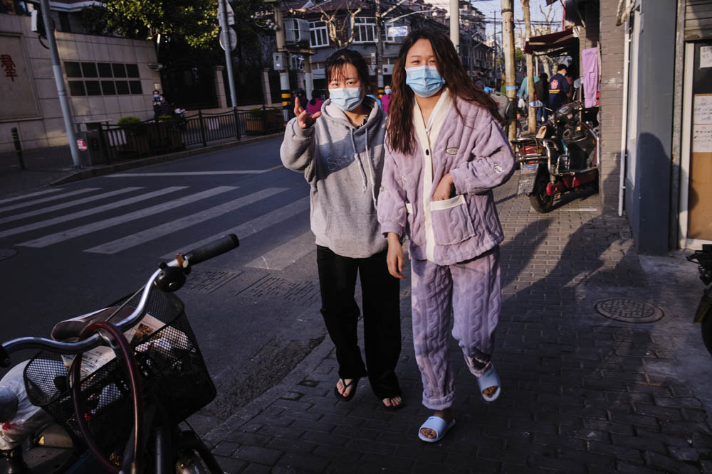 Two women walk home after finishing their COVID-19 test in Laoximen Subdistrict, Shanghai, March 15, 2022. Wu Huiyuan/Sixth Tone