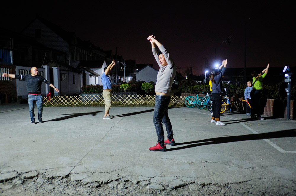 Residents flex their moves in a dance routine at a square in Gucun Town, Shanghai, March 16, 2022. Wu Huiyuan/Sixth Tone