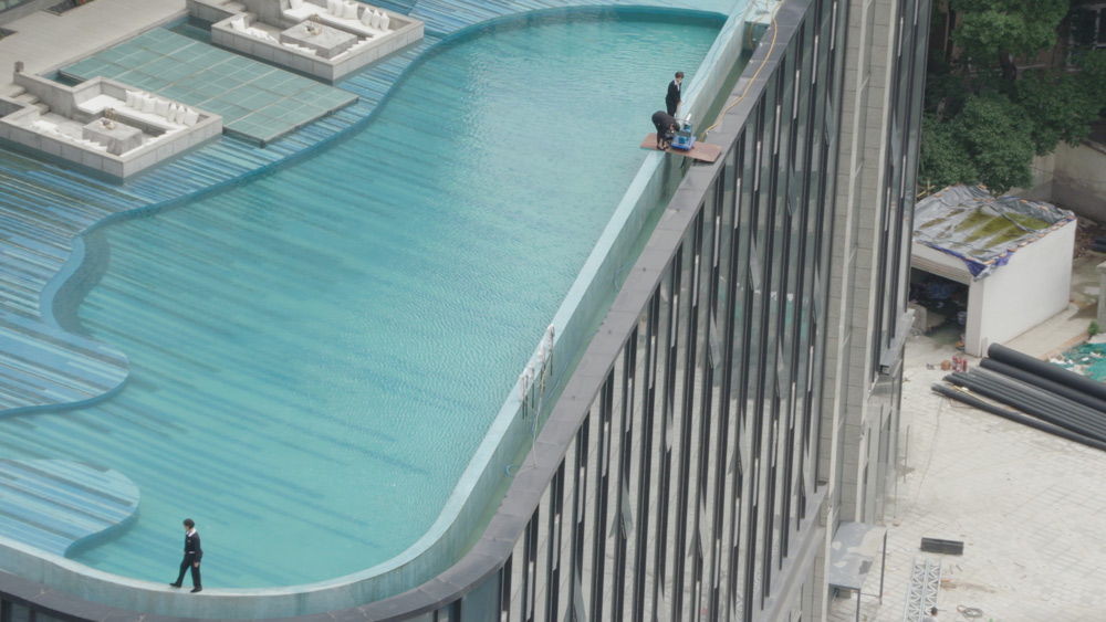 A still from the documentary “Ascension” shows staff working on a rooftop infinity pool in Chengdu, Sichuan province. Courtesy of MTV Documentary Films