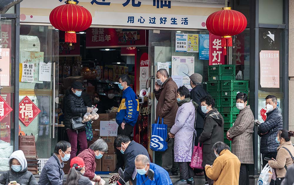 People wait to get inside a grocery store, in Shanghai, March 22, 2022. IC