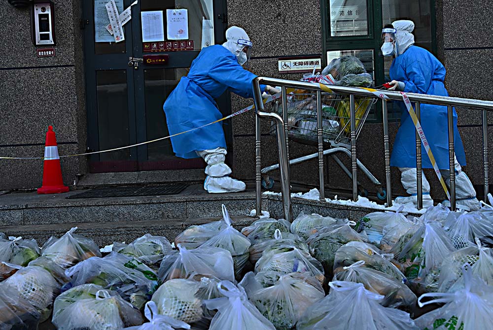 Volunteers send vegetables to a compound in Jilin, Jilin province, March 17, 2022. VCG