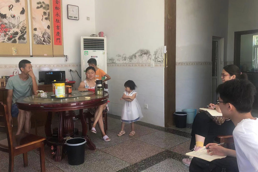 Qi Weiwei’s team talks to a mother who returned to the countryside to take care of her children. Courtesy of Qi Weiwei