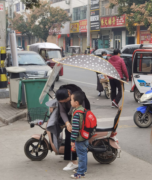 A mother picks up her son after school, Henan province, 2020. Courtesy of Qi Weiwei