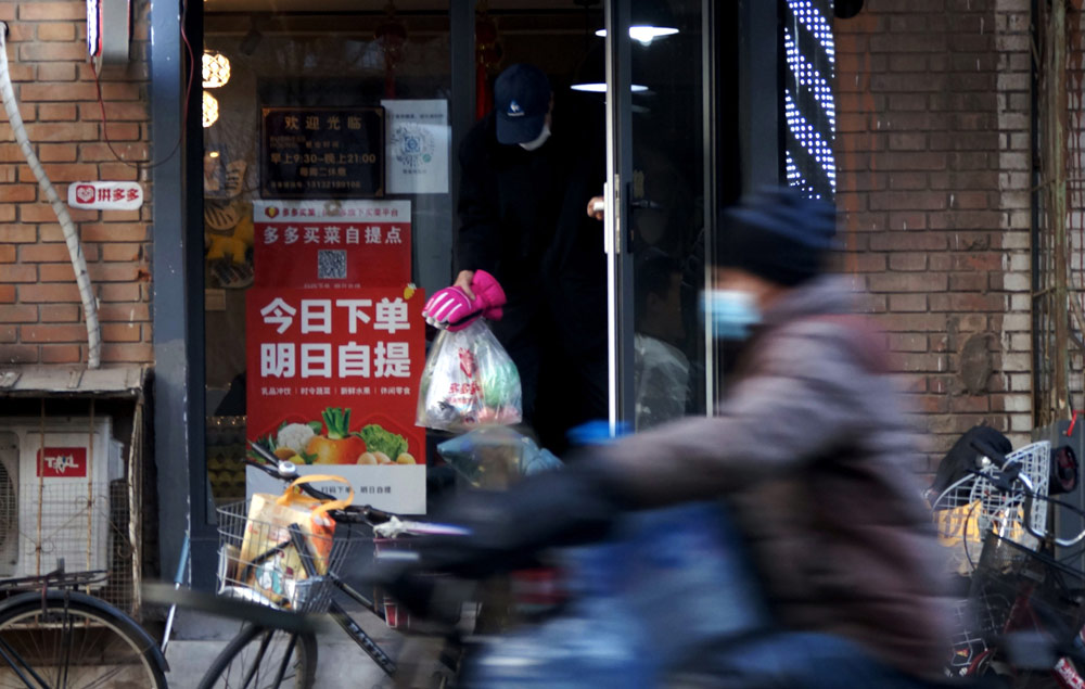 A man exits a Duo Duo Grocery store in Tianjin, 2020. VCG