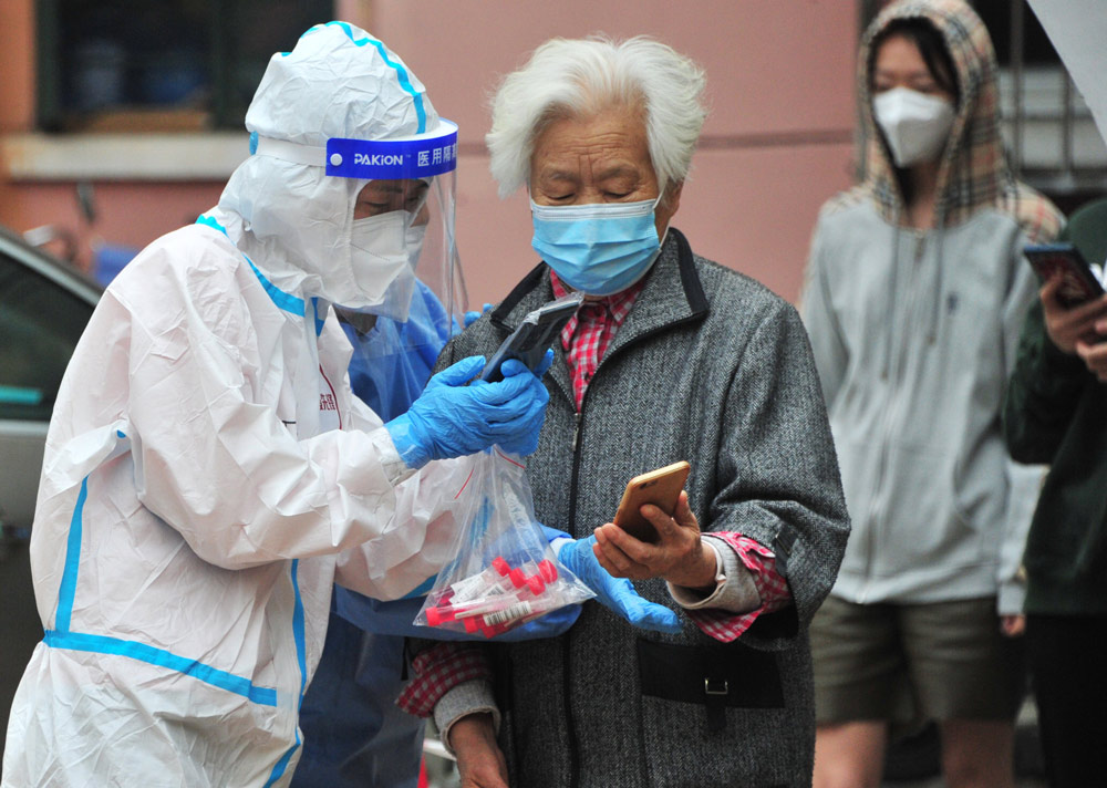 A medical worker scans a QR code in Shanghai, April 16, 2022. IC
