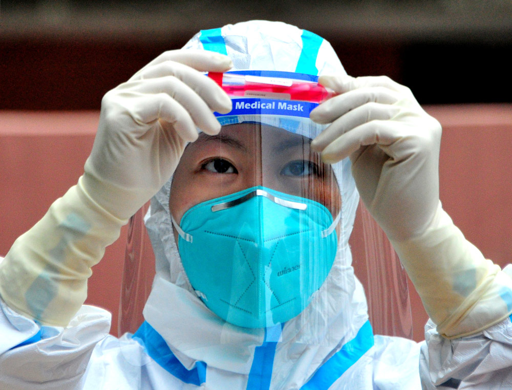 A medical worker from Zhejiang province checks a sample in Shanghai, April 16, 2022. IC