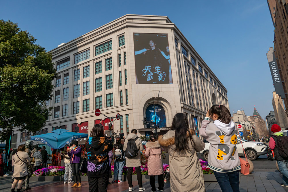 Fans take photos of a billboard displaying their idol’s photo, in Shanghai, March 2021. Wang Gang/VCG