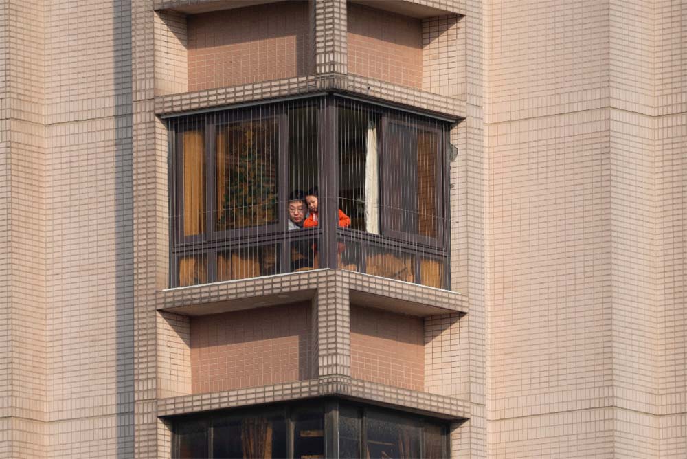 A father and a son looks out of a window at home in Shanghai, May 2, 2022. VCG