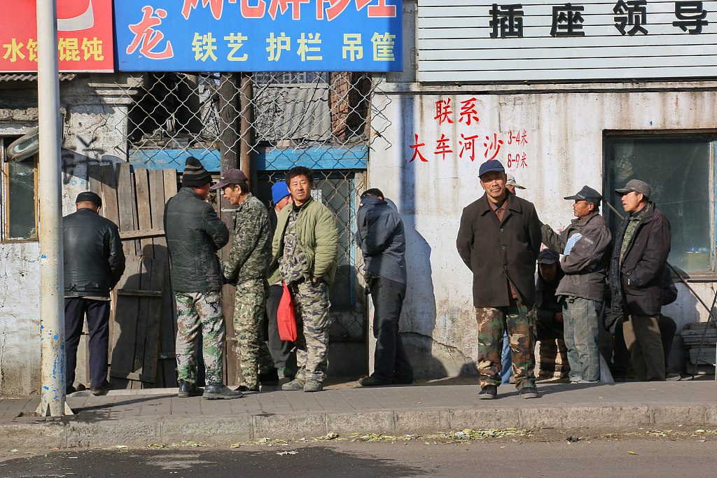 Workers wait for odd jobs in Hegang, Heilongjiang province, 2015. VCG