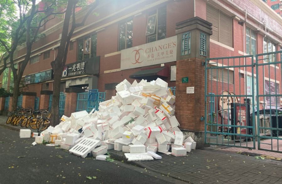 Packaging boxes are piled up next to a compound gate in Changning District, Shanghai, May 23, 2022. Dave Cohen/Sixth Tone