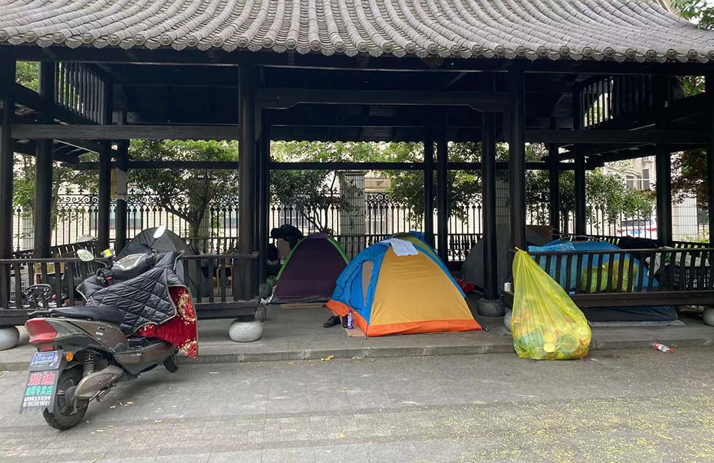 Tents in a pavilion where delivery drivers has been living for the last two months, Baoshan District, Shanghai, May 27, 2022. Xie Anran/Sixth Tone