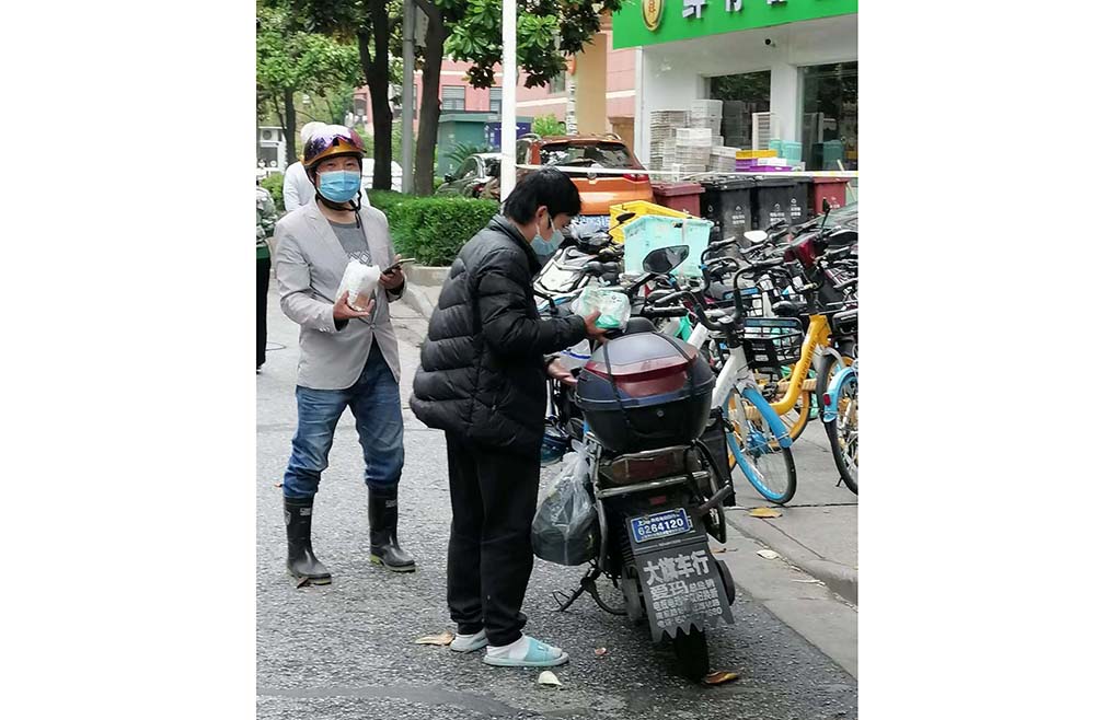 A photo taken by Lü Shujuan shows a delivery man wearing a down jacket in summer, two months after leaving home in winter weather. Courtesy of Lü